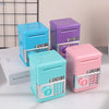 A set of colorful mini piggy banks and money boxes in blue, purple, and pink plastic.