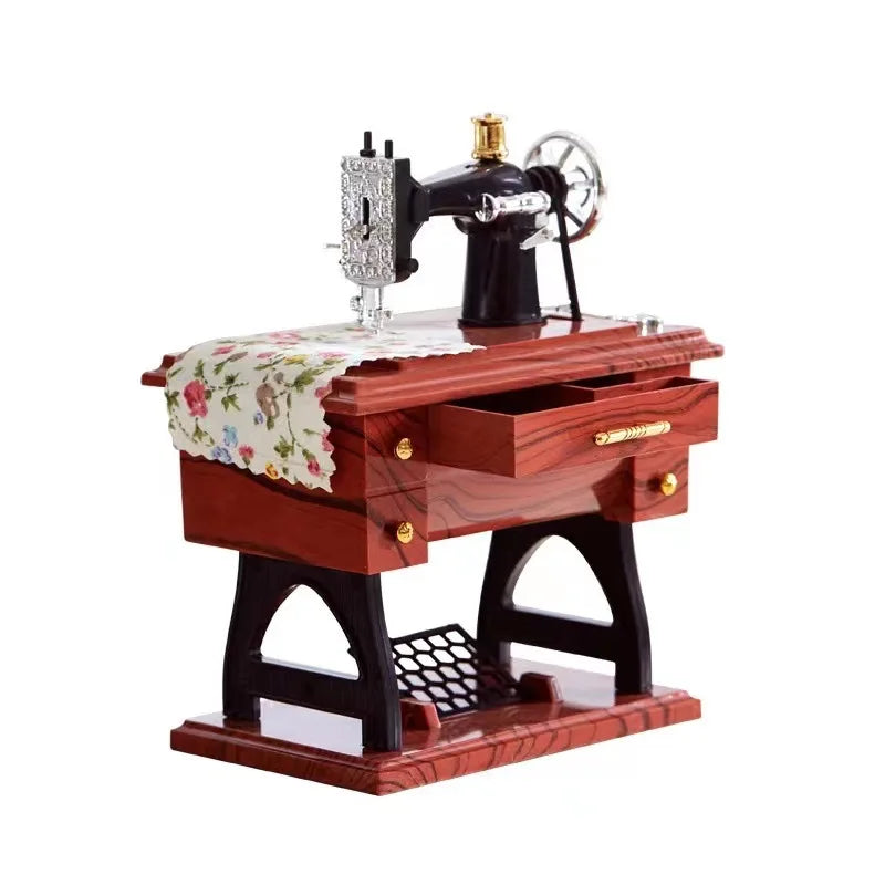 A vintage miniature sewing machine with a wooden base and patterned cloth is displayed.