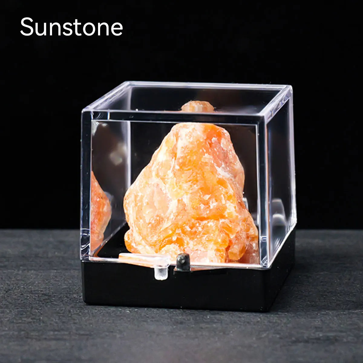 A rough, translucent orange-yellow gemstone specimen is displayed inside a clear acrylic box.