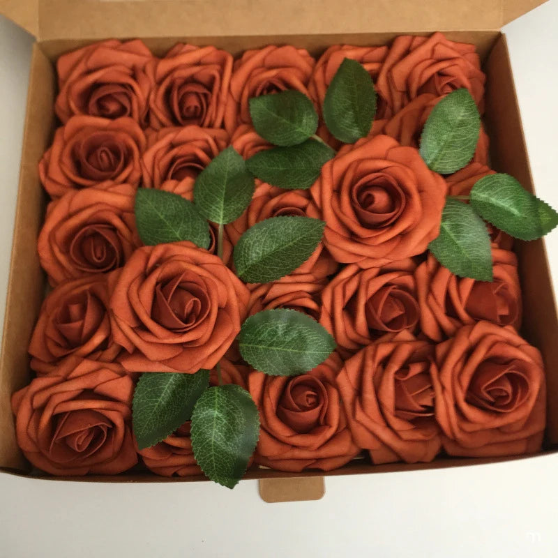 A box filled with artificial real touch foam roses in shades of burnt orange and terracotta.