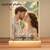 A personalized acrylic photo frame displaying a photo of a couple and custom text, featuring a wooden base.