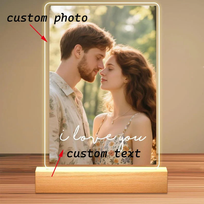 A personalized acrylic photo frame displaying a photo of a couple and custom text, featuring a wooden base.