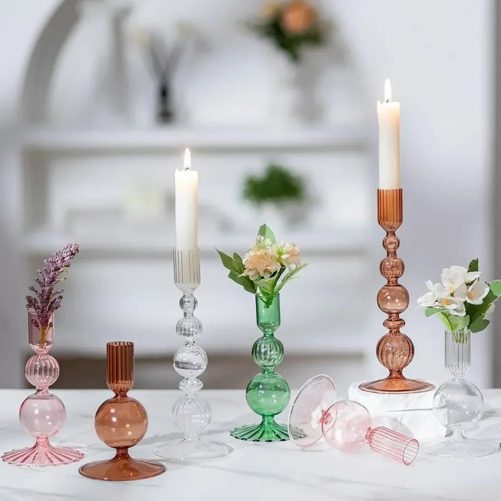 A set of three groovy wavy glass taper candle holders in pink and amber tones displayed on a white surface.