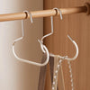 A set of round metal hooks hanging from a wooden rod, used for hanging hats, ties, scarves, and bags.