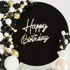 Black backdrop decorated with gold and black balloons and silver script reading Happy Birthday and a pink bear figure