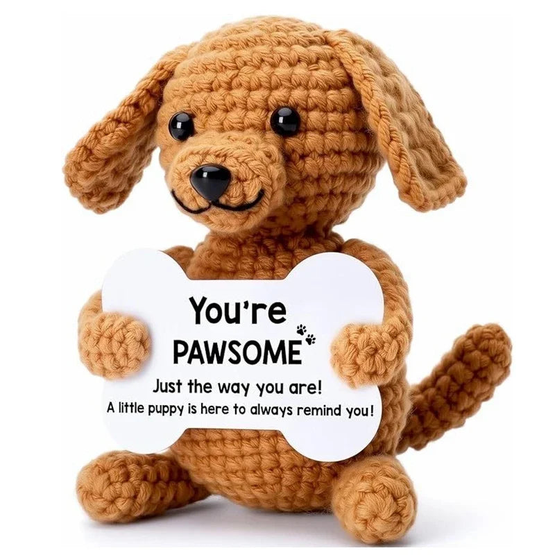 Handcrafted crochet dog doll in brown yarn with a white card that reads You're pawsome
