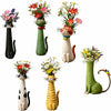 A collection of whimsical resin cat flower vases in various colors and styles.