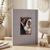 A square linen photo album with a gray cover displaying a wedding portrait of a couple.