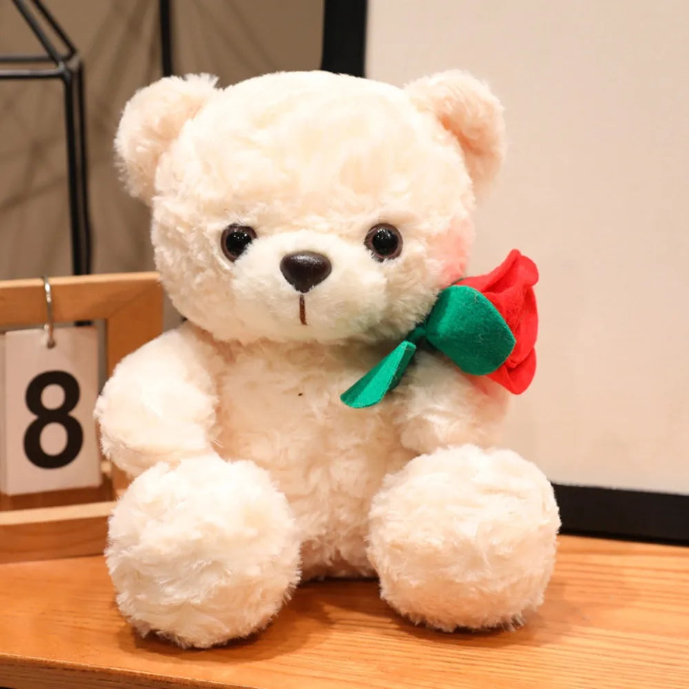 A fluffy white bear plush toy with a red rose accessory sitting on a wooden surface.