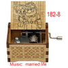 A wooden music box featuring a line drawing of a couple, with a crank mechanism and decorative wood carving.