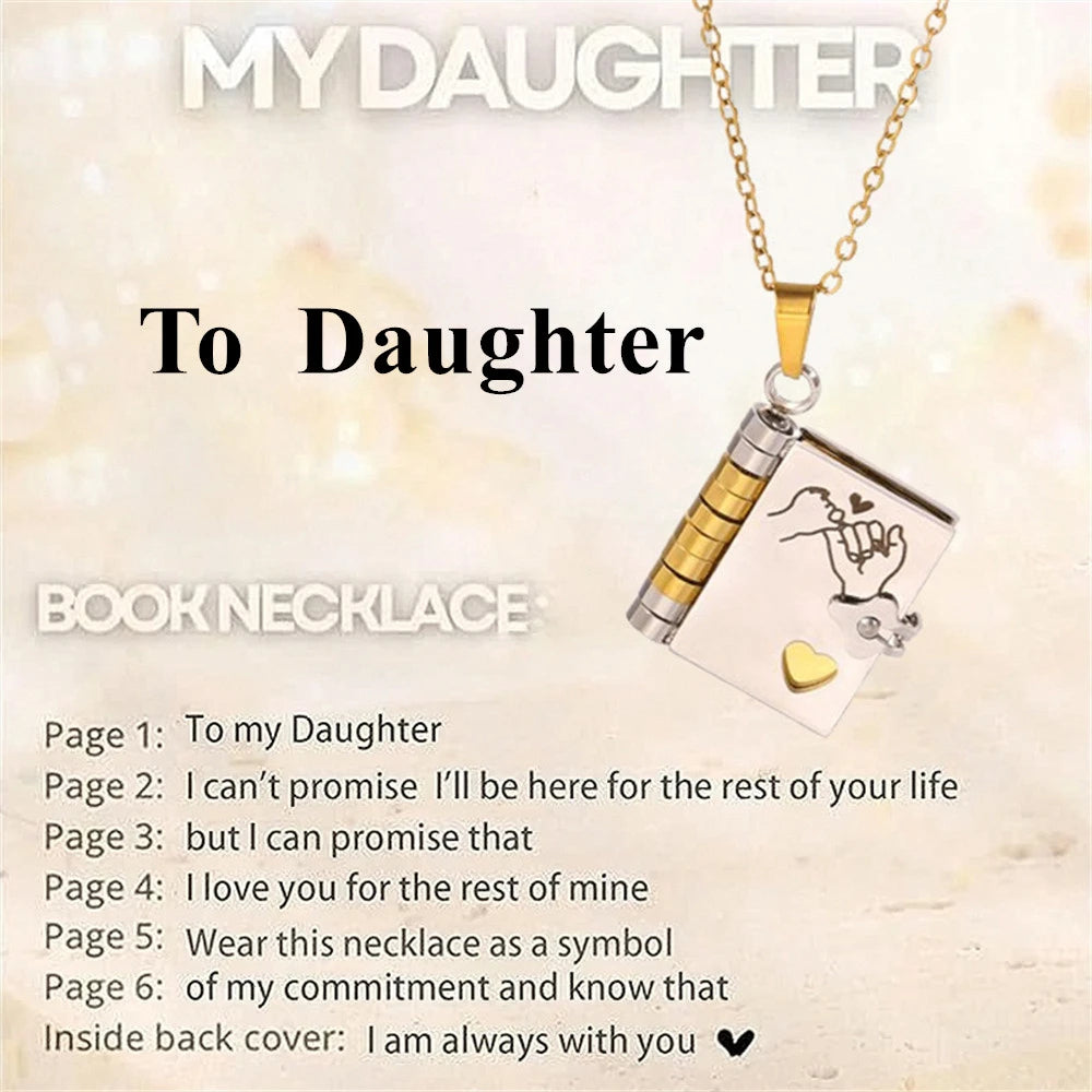 A silver book necklace with an engraved message on the pendant and a gold chain.