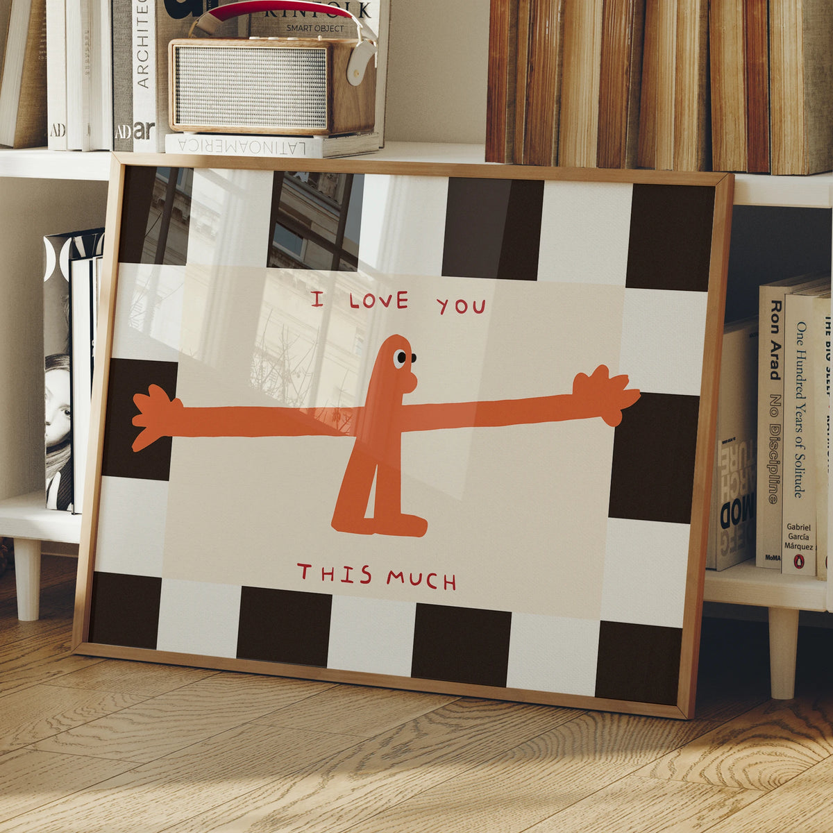 A framed wall art print featuring an orange silhouette of a person and the text I love you this much on a black and white che