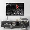 A framed canvas wall art depicting a basketball player performing a slam dunk in an arena setting.