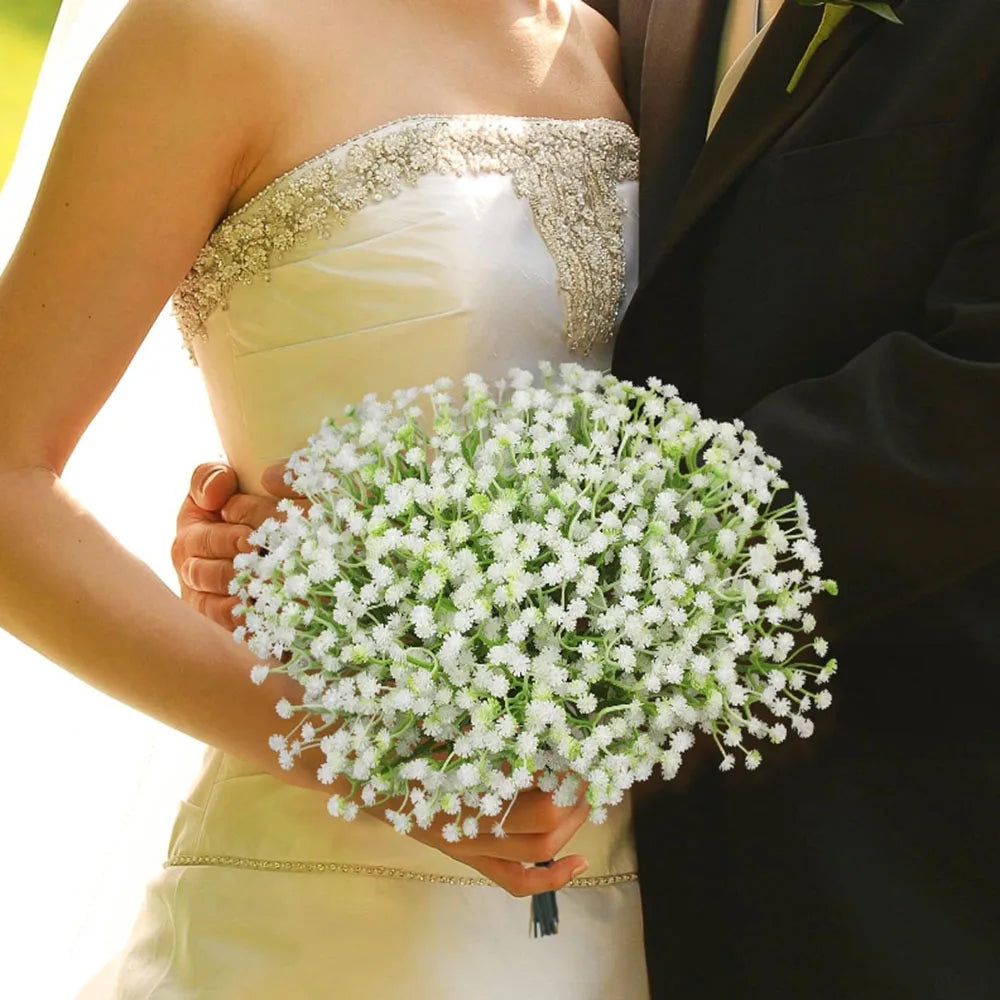 A woman holds a bouquet of white baby's breath flowers against a dark suit jacket.
