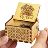 A carved wooden music box with a lid featuring an eagle design is held in a hand.