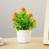 A potted artificial bonsai tree with bright orange flowers and vibrant green leaves on a light background.