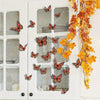 A white door features glass panels decorated with twelve orange and black monarch butterfly decals and yellow autumn vines.