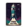 Una placa oscura con un diseño estilizado de nave espacial y la bandera de Estados Unidos y el texto FOO FIGHTERS.