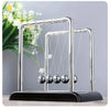 Silver Newton's cradle with balance balls on a black base for desktop decor