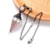 A set of natural crystal pendulum necklaces featuring clear quartz and silver accents displayed on a wooden surface.