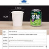A green aluminum can of beverage next to a white disposable paper cup and product information details.