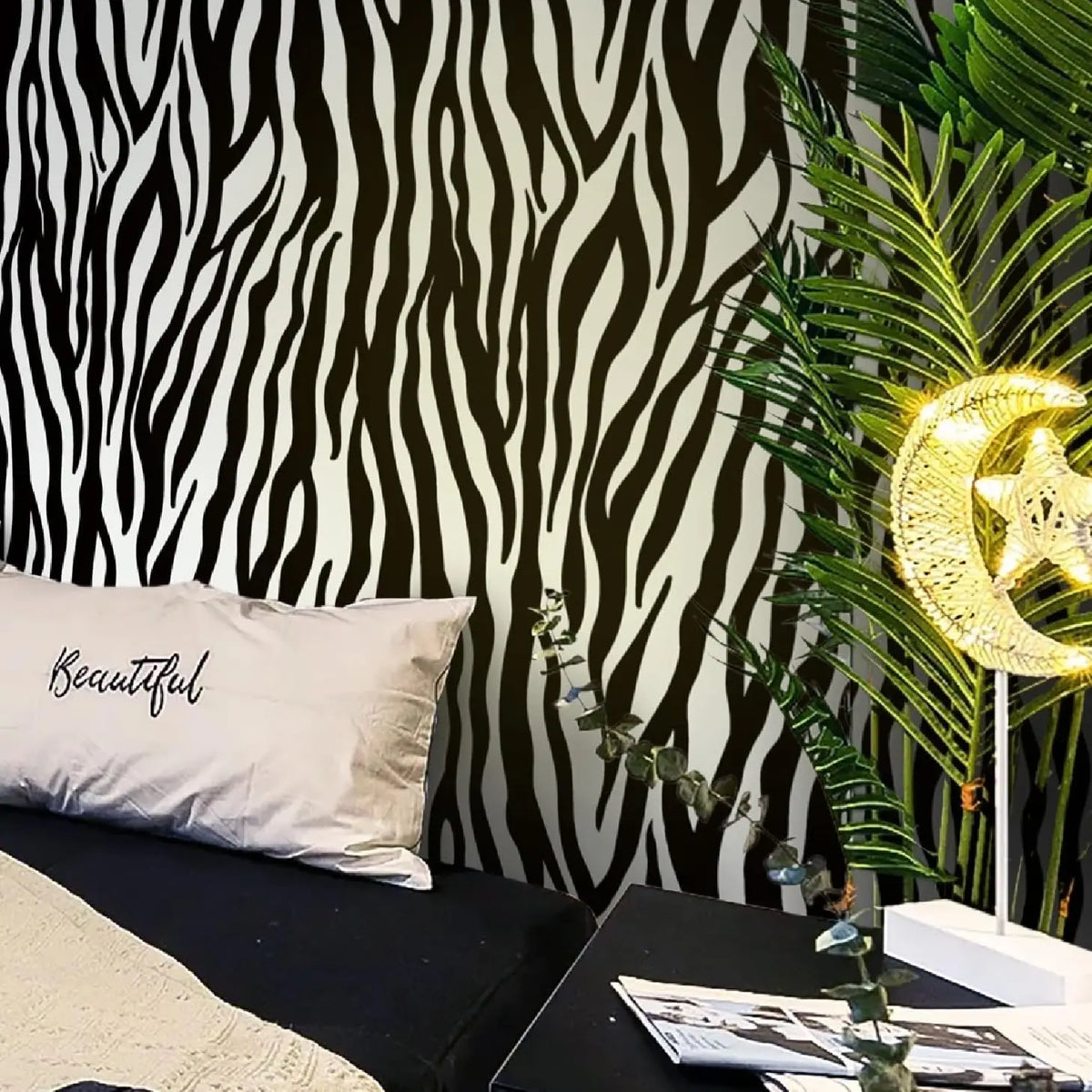A close-up of a black and white zebra print wallpaper featuring a large leaf and a glowing star accent.