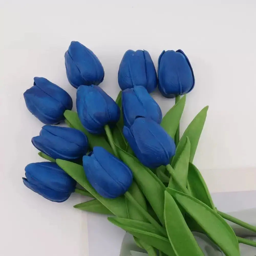 A bouquet of deep blue artificial tulips with green stems and leaves.