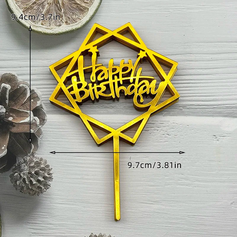 A gold acrylic birthday cake topper featuring the words Happy Birthday shaped like a hexagon on a stick.