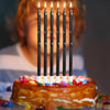 A cake decorated with colorful candies and a set of 24 gradient blue metallic birthday candles