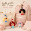 A pink backpack features four color options of cute curly girl charm plush keychains.