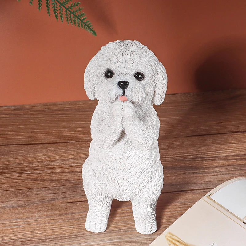 Petite statue de chien en résine blanche et duveteuse, pattes jointes, sur une surface en bois.
