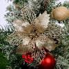 Gold sparkle silk artificial Christmas flowers with intricate netting on a green fir branch
