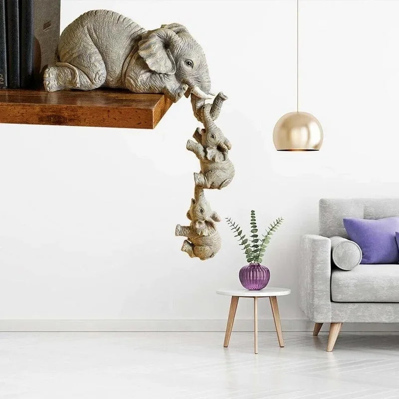 A resin figurine of an elephant hugging a baby, hanging from a wooden shelf.