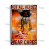 Vintage metal sign featuring a firefighter wearing a helmet and gear with the text NOT ALL HEROES WEAR CAPES