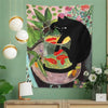 A tapestry featuring a black cat looking out of a glass bowl filled with goldfish on a green and pink floral background.