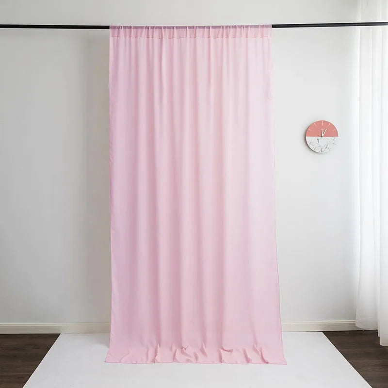 A sheer pink chiffon backdrop curtain hanging in a room.