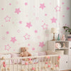 Pink star vinyl wall decal featuring various sized stars on a white wall.