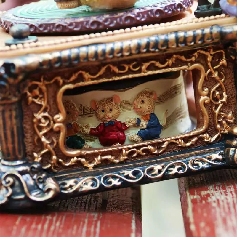 A close-up of a retro carousel music box decoration featuring a small figurine inside an ornate frame.