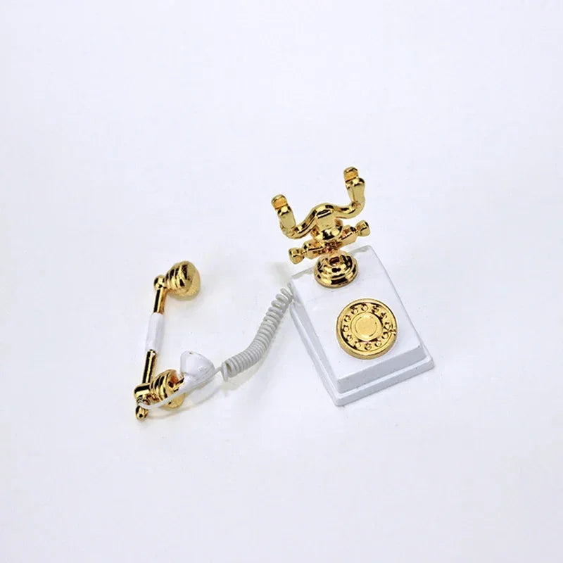 A miniature vintage rotary desk phone with a coiled cord and gold accents displayed on a clear stand.