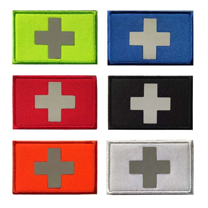 A collection of nine rectangular patches featuring a silver cross on various colored backgrounds including lime green, blue, 