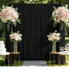 Elegant wrinkle-free black drapery backdrop for a wedding ceremony area decorated with pink and white floral arrangements
