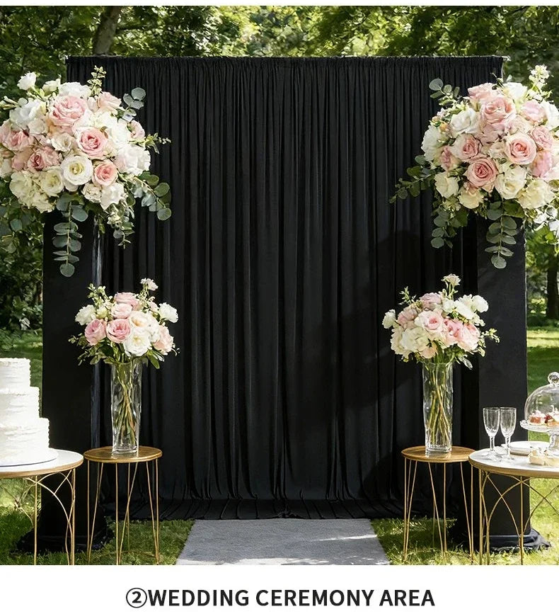 Elegant wrinkle-free black drapery backdrop for a wedding ceremony area decorated with pink and white floral arrangements