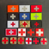 A collection of various colored and patterned medical cross patches on a dark background.