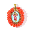 A gold-colored pendant featuring a small figure of the Virgin Mary surrounded by red beads.