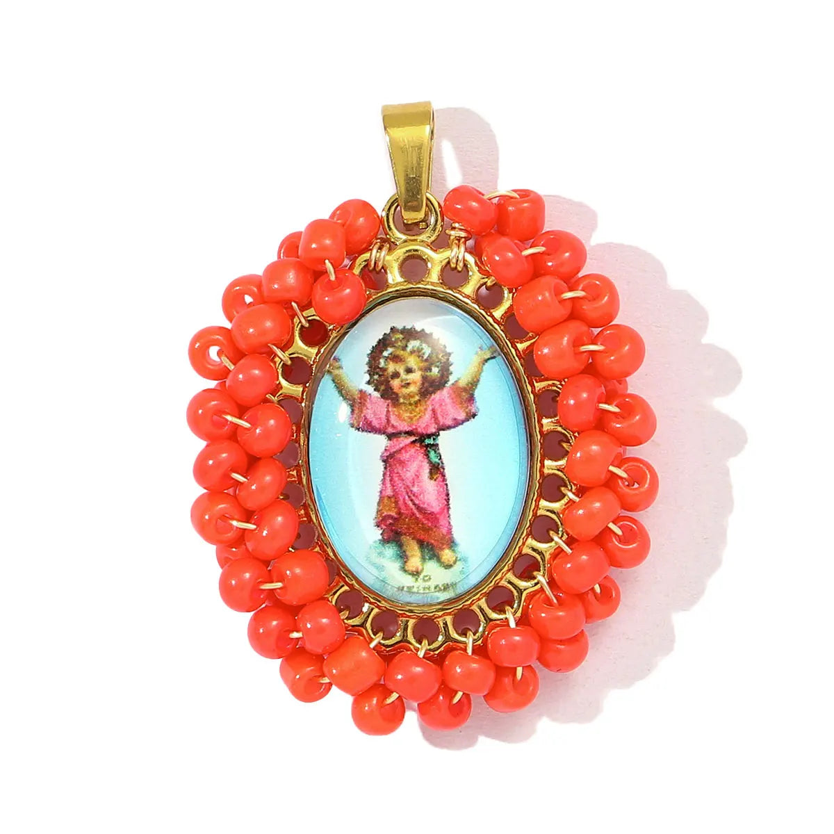 A gold-colored pendant featuring a small figure of the Virgin Mary surrounded by red beads.