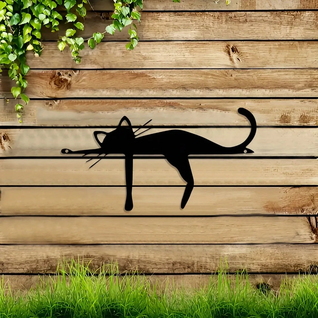 A silhouette of a cat is displayed on weathered wooden planks with green vines above and grass below.