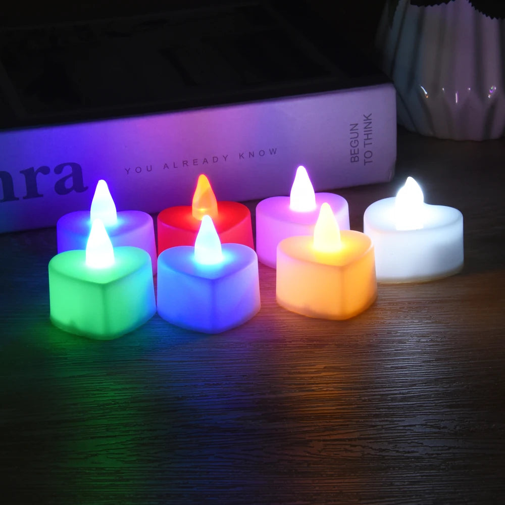 A collection of colorful LED heart-shaped tealight candles glowing in various shades of purple, pink, green, and white.