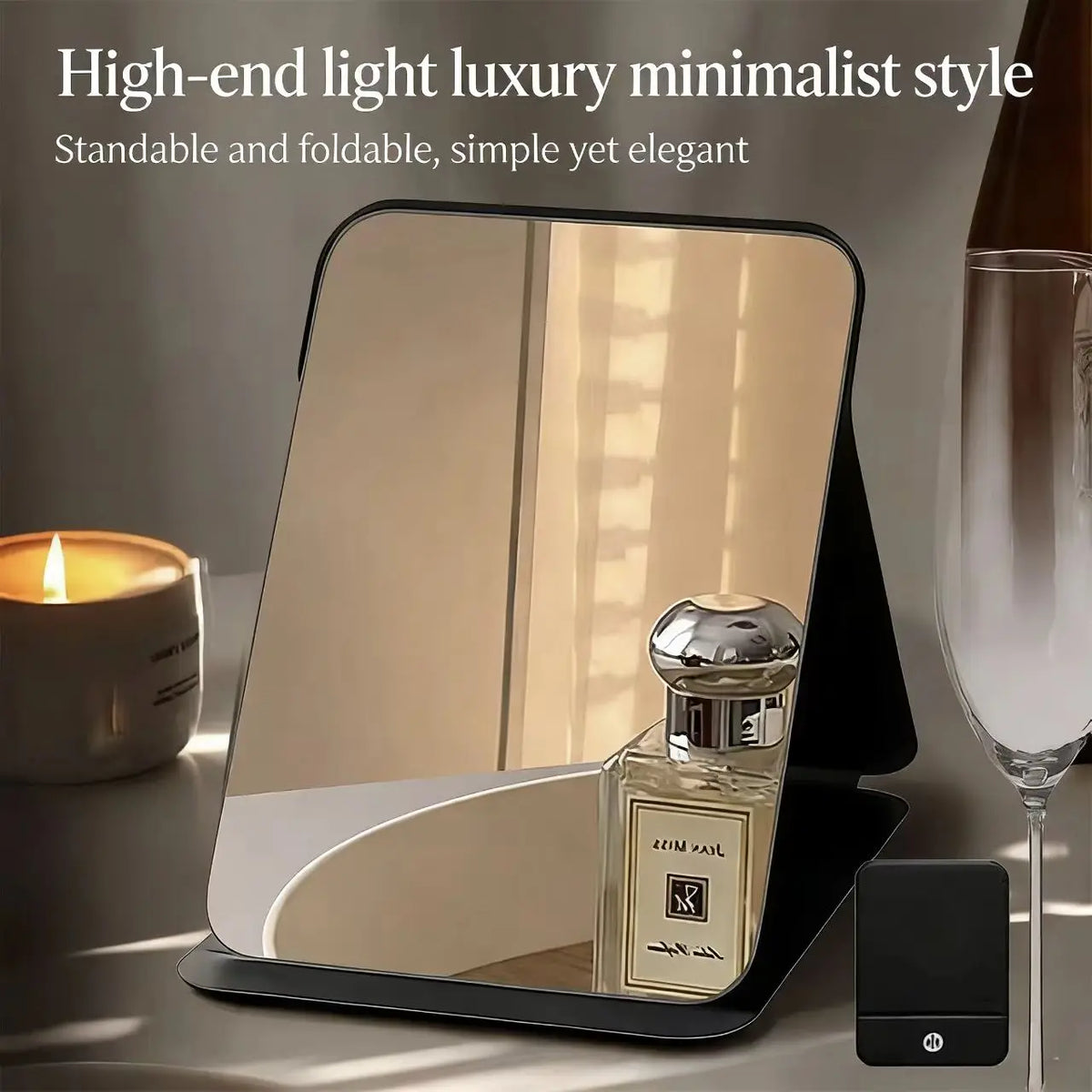 A high-end light luxury minimalist foldable vanity mirror with a glass perfume bottle displayed on a black stand.
