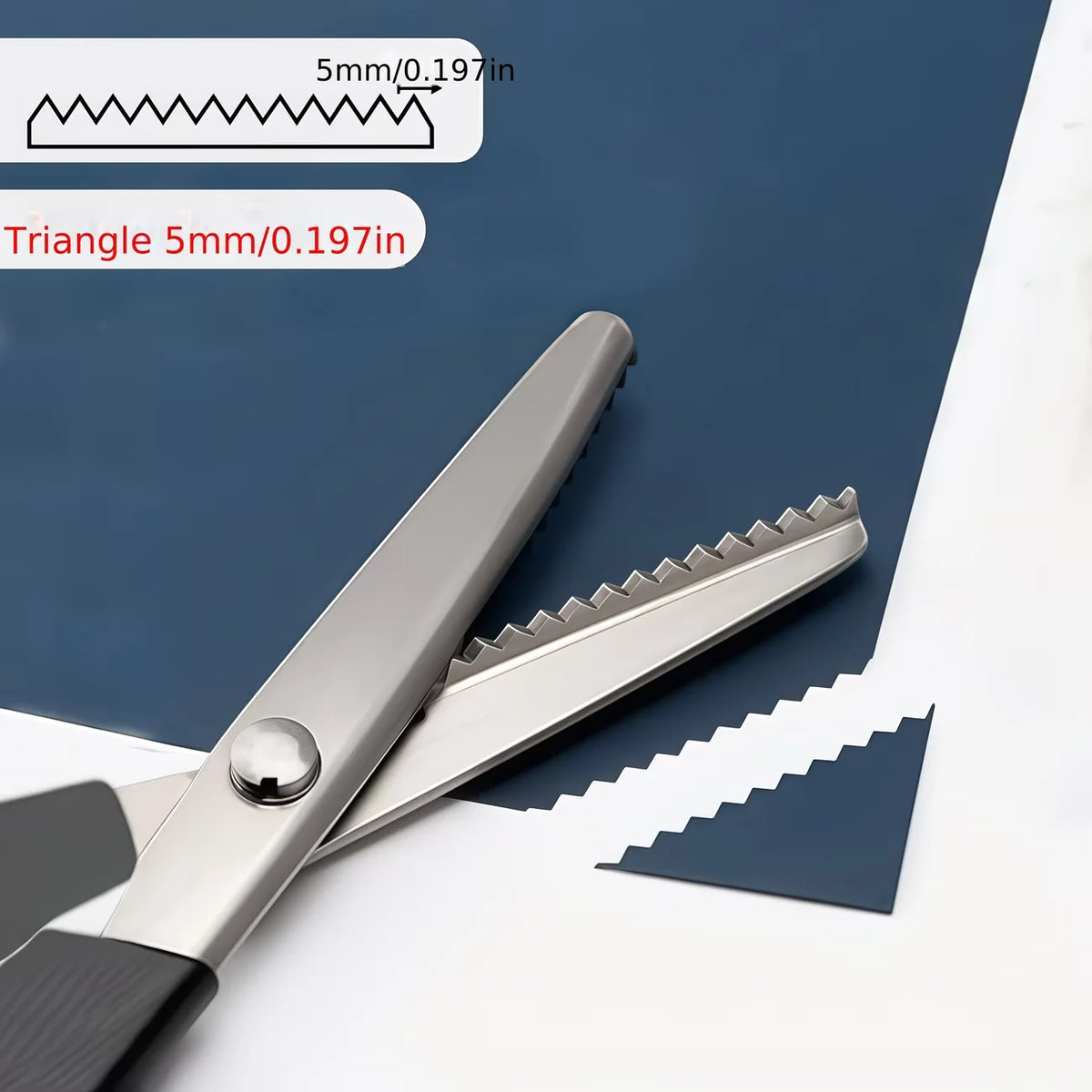 Stainless steel pinking scissors showing a zig zag blade and a measurement guide.
