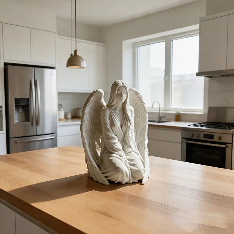 Estatua de mármol blanco de un ángel con alas sobre una encimera de madera en una cocina moderna.
